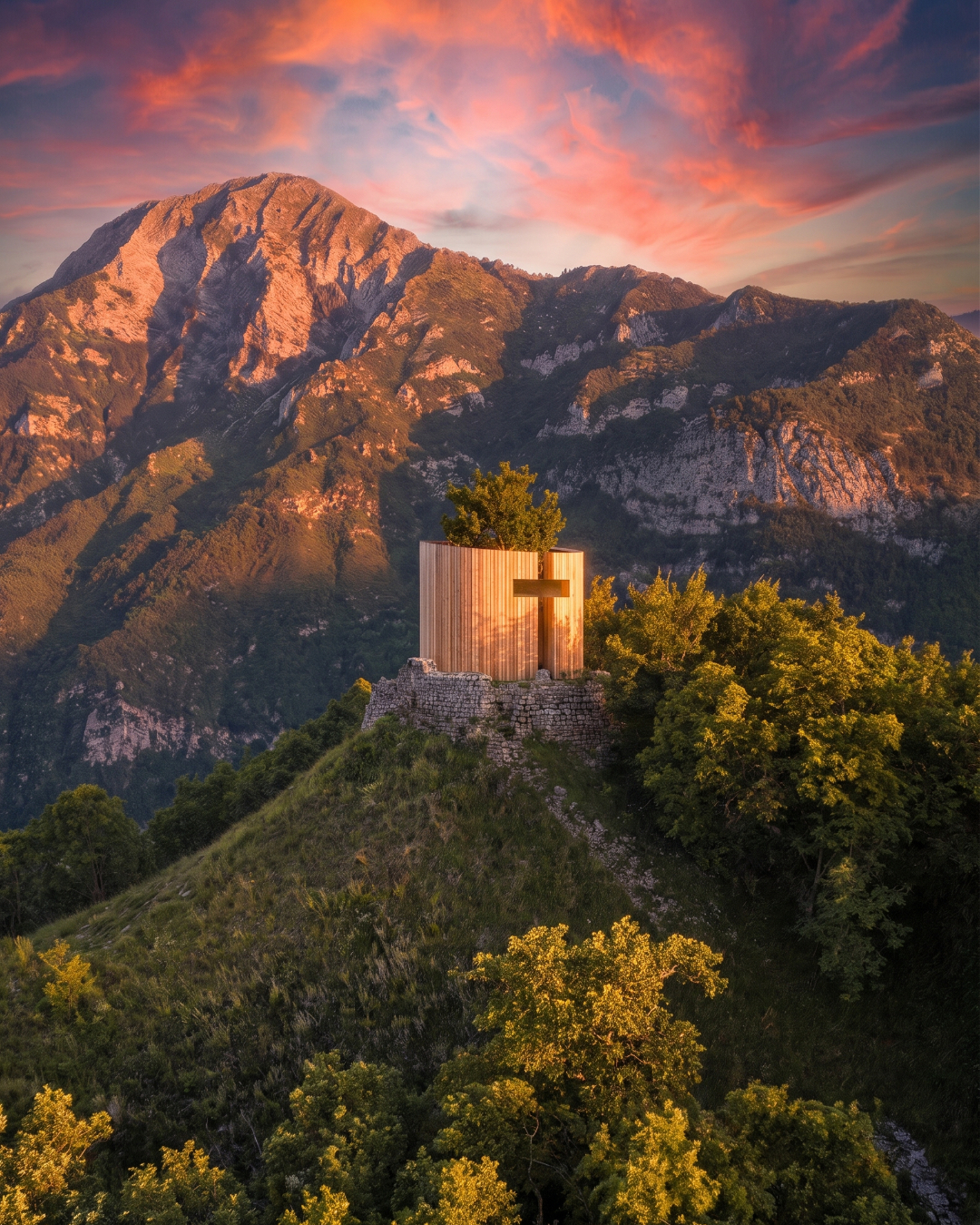 Render di The Sacred Enclosure al tramonto nel paesaggio montano.